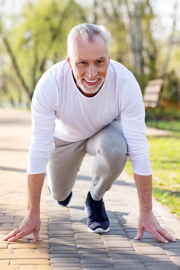 Degenerative-Disc-Disease-Treatment An older man sets in starting position for a run. Get treatment for degenerative disc disease from Lux Hormones & Health Wellness in San Diego.