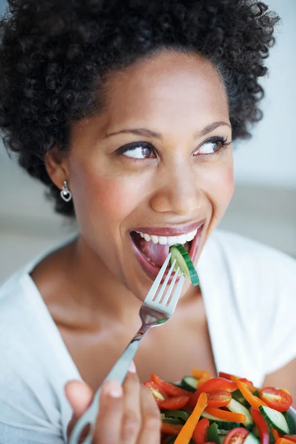 Lipo-Mino-Vitamin-Shot-Treatment A happy black woman eating a healthy salad. Get Lipo-Mino vitamin shots for weight loss from Lux Hormones & Health Wellness in San Diego.