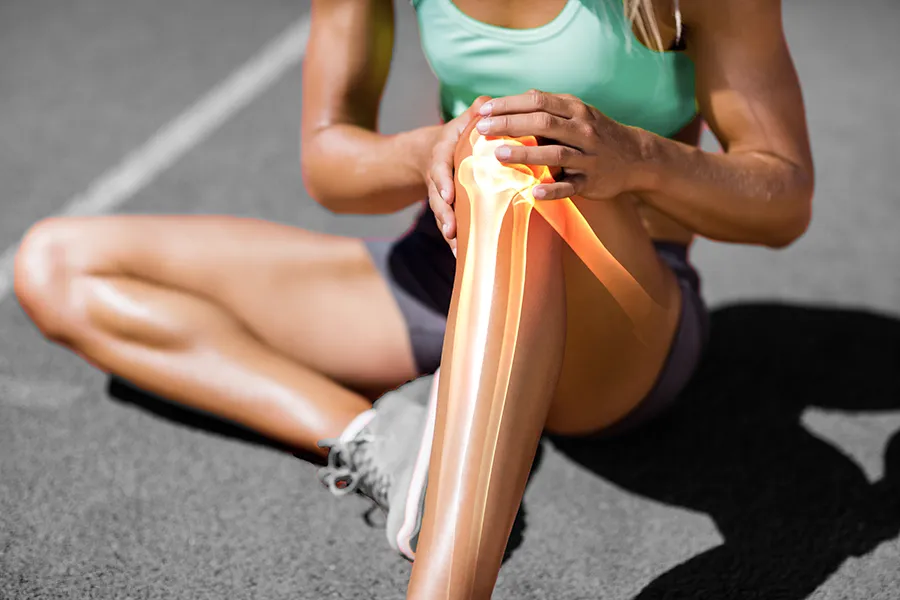 MCL-Tears-Clinic A female runner sits on the track and holds her knee in pain. Schedule treatment for MCL tears from Lux Hormones & Health Wellness in San Diego.