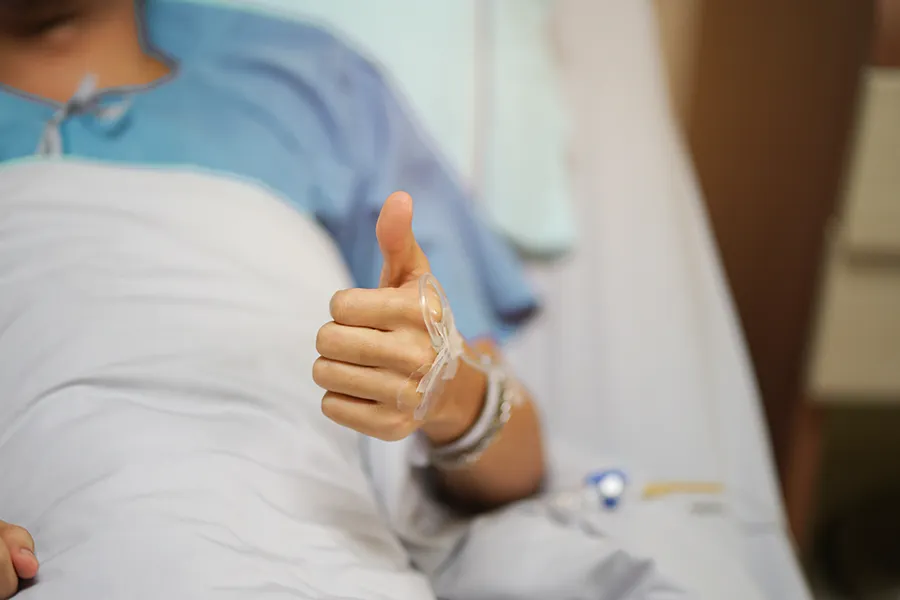 Post-Surgical-Recovery-Clinic A man in a hospital bed gives a thumbs up. Get post-surgical recovery treatment from Lux Hormones & Health Wellness in San Diego.